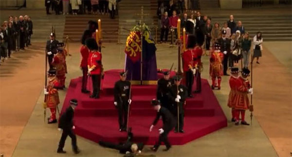 රැජිනගේ දේහය අසල සිටි ආරක්ෂකයෙක් ඇද වැටෙයි